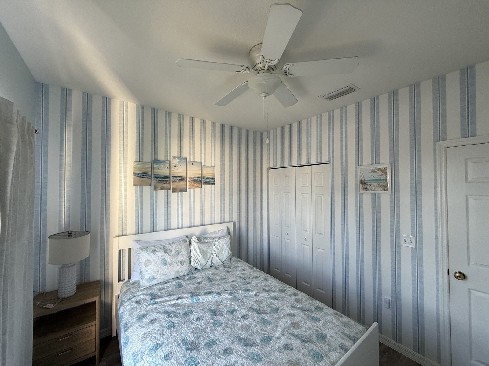 Tailored striped wallpaper professionally installed in a bright bedroom